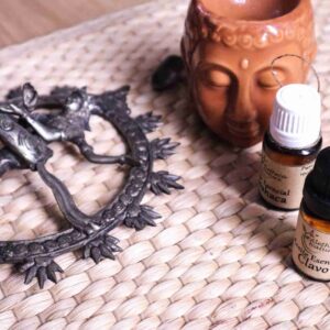 Aceites esenciales, figurilla y objeto metálico decorativo.