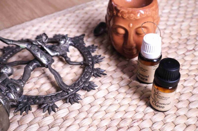 Aceites esenciales, figurilla y objeto metálico decorativo.