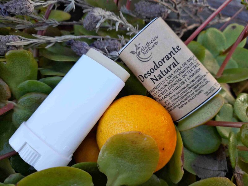Desodorante natural con limón sobre hojas verdes.