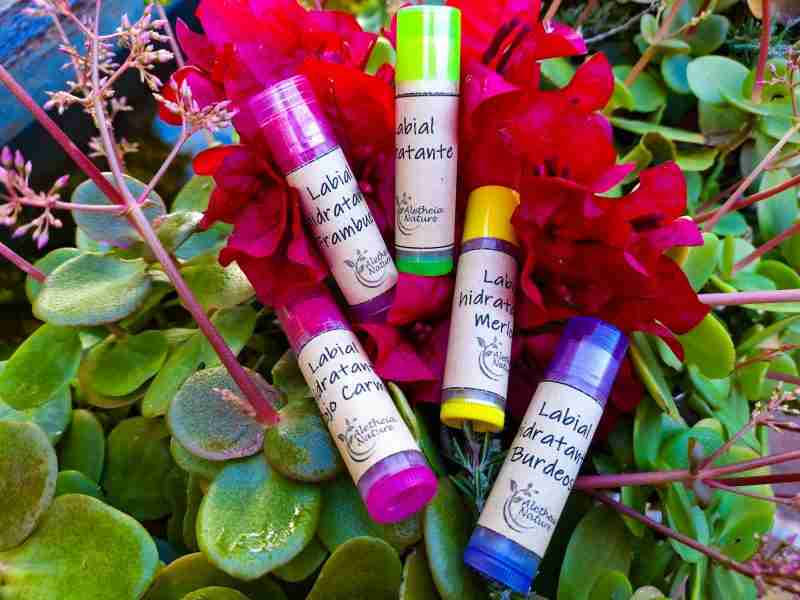 Bálsamos labiales naturales entre flores y plantas.