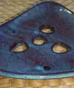 Soporte incienso cerámico sobre superficie tejida.