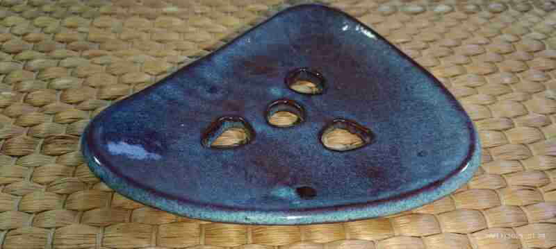 Soporte incienso cerámico sobre superficie tejida.