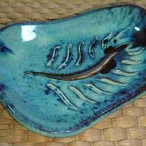 Plato cerámico artesanal azul sobre mimbre.