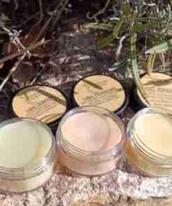 Bálsamos labiales naturales sobre piedra y vegetación.