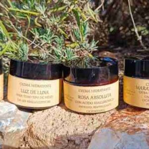 Cremas hidratantes naturales sobre piedra y vegetación.