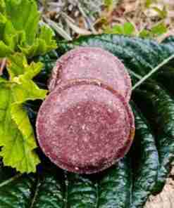 Tubérculos morados sobre hojas verdes.